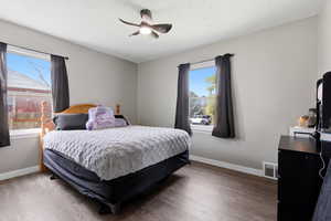 Bedroom with dark wood-style flooring and a ceiling fan