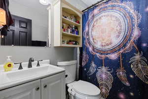 Full bath with curtained shower and vanity