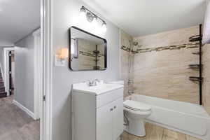 Bathroom featuring vanity, tub / shower combination, and light wood-style flooring