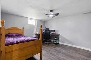 Bedroom with a textured ceiling, wood finished floors, and ceiling fan