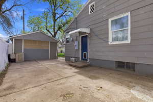 View of side of home featuring a detached garage and an outdoor structure