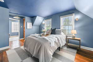 Bedroom with wood-type flooring and lofted ceiling