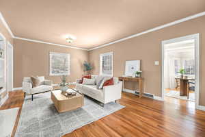 Living room with hardwood / wood-style flooring, ornamental molding, and plenty of natural light