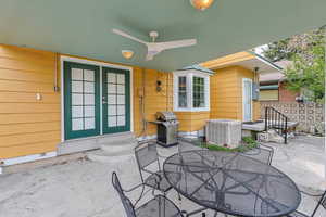 View of patio with outdoor dining space, grilling area, entry steps, french doors, and ceiling fan