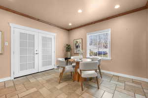 Dining space with french doors, recessed lighting, crown molding, and stone tile floors