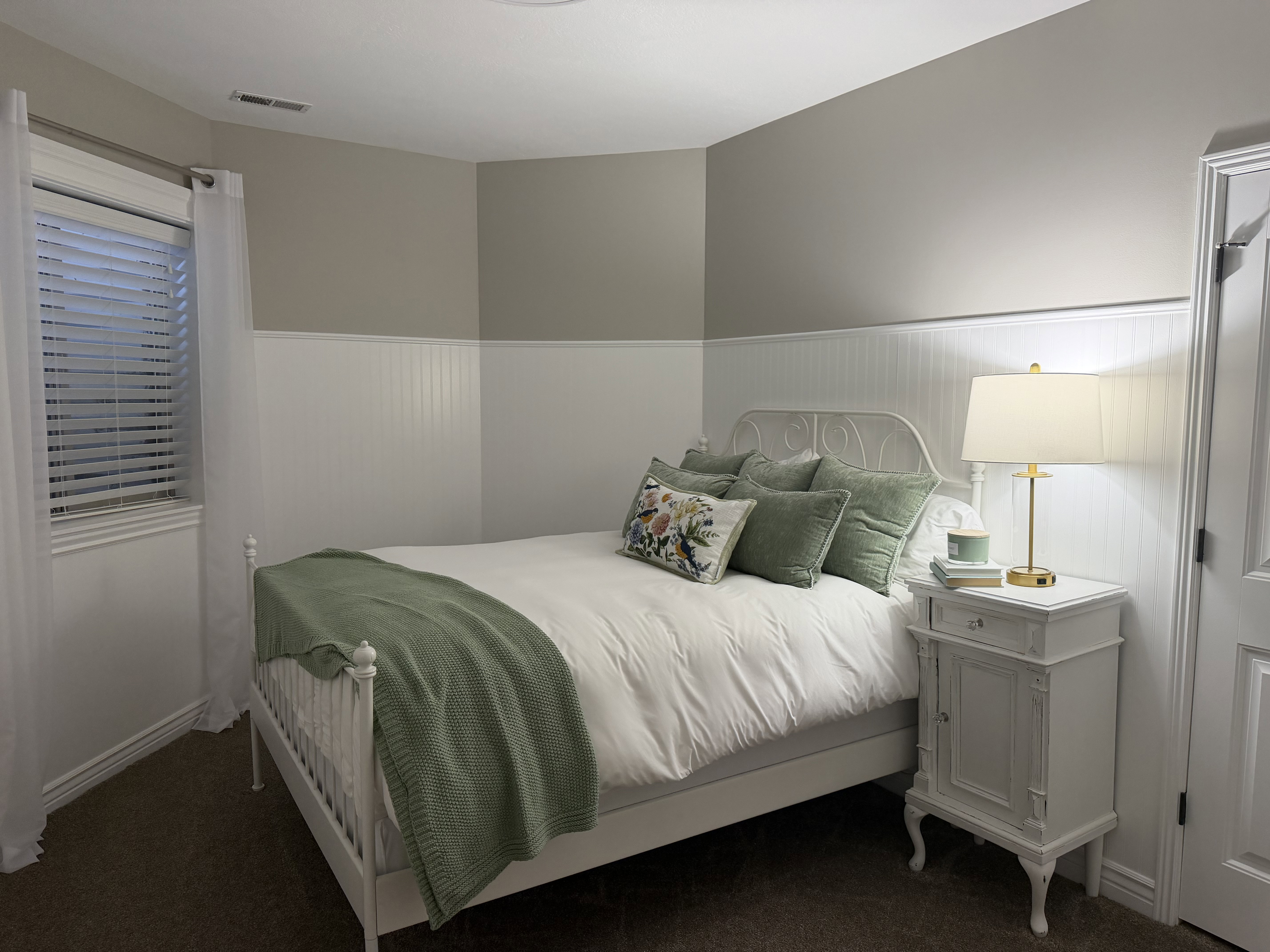 Bedroom with wainscoting and dark carpet