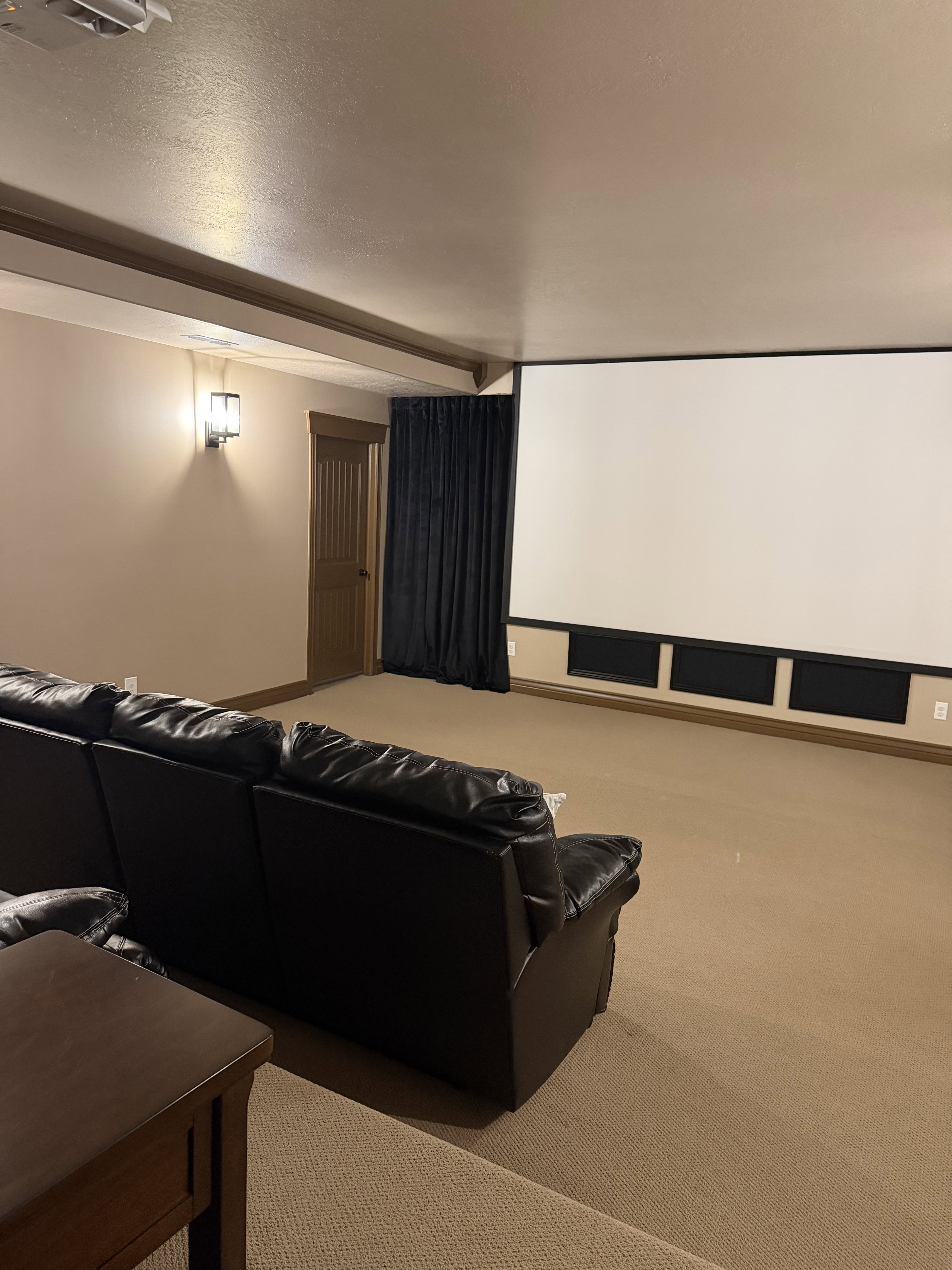 Carpeted cinema room featuring a textured ceiling and beam ceiling
