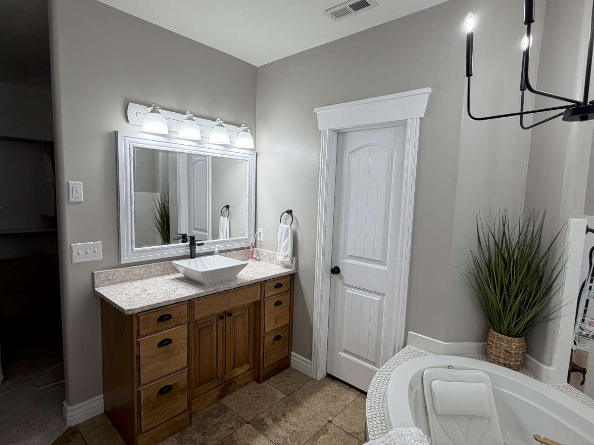 Full bathroom featuring vanity, a bath, and light tile patterned flooring