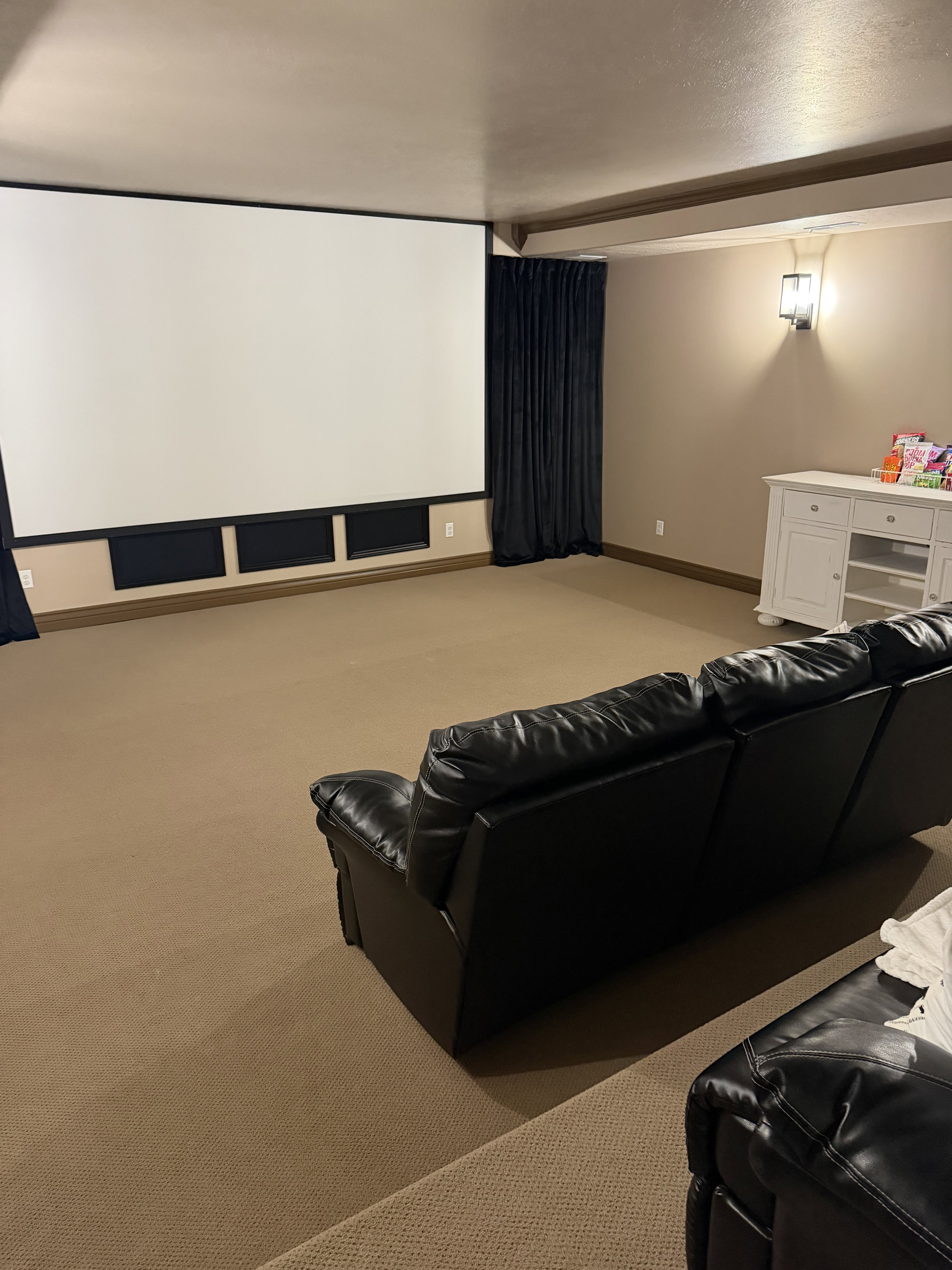 Cinema room with light colored carpet and a textured ceiling