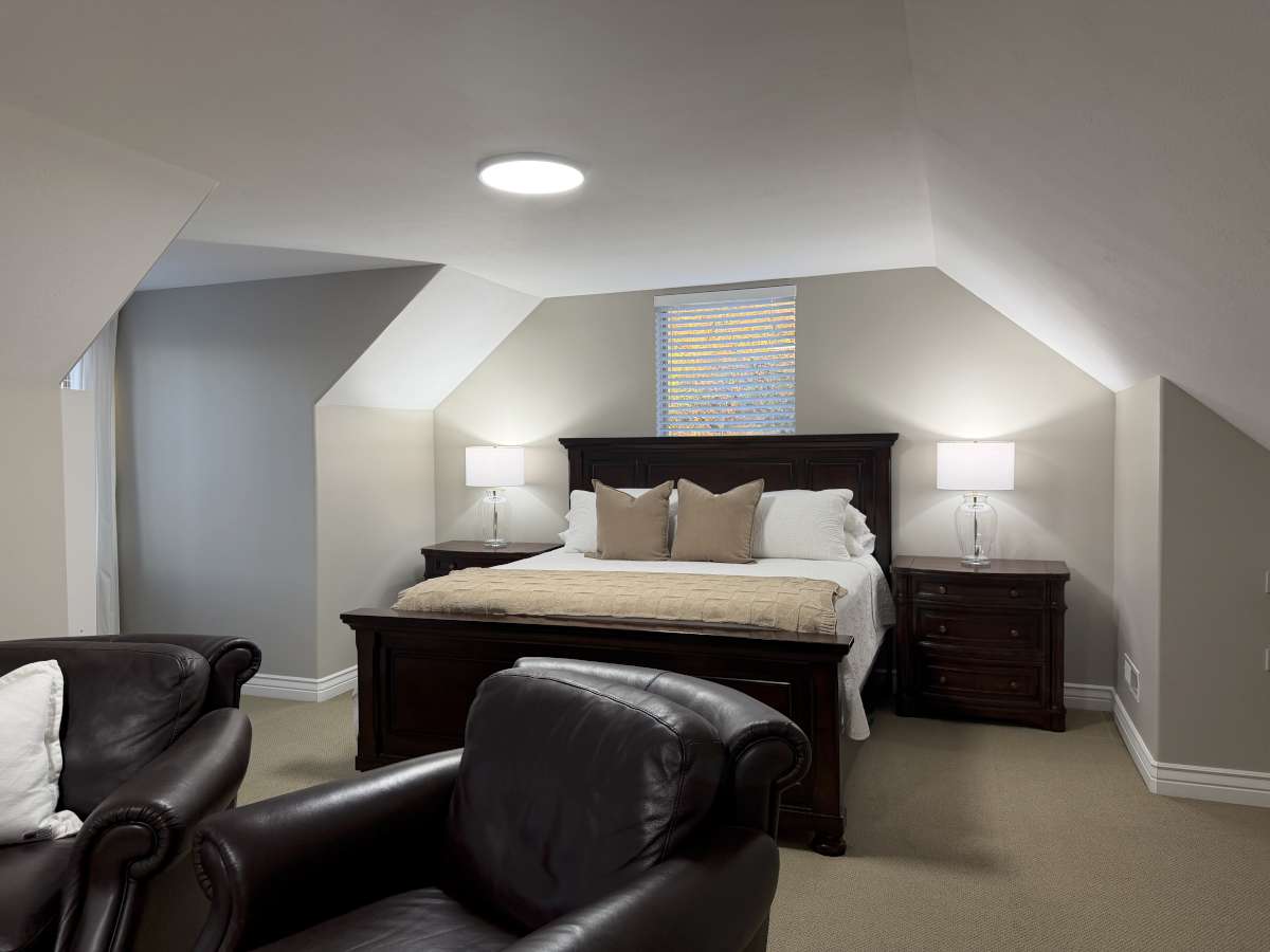 Bedroom featuring light colored carpet and lofted ceiling