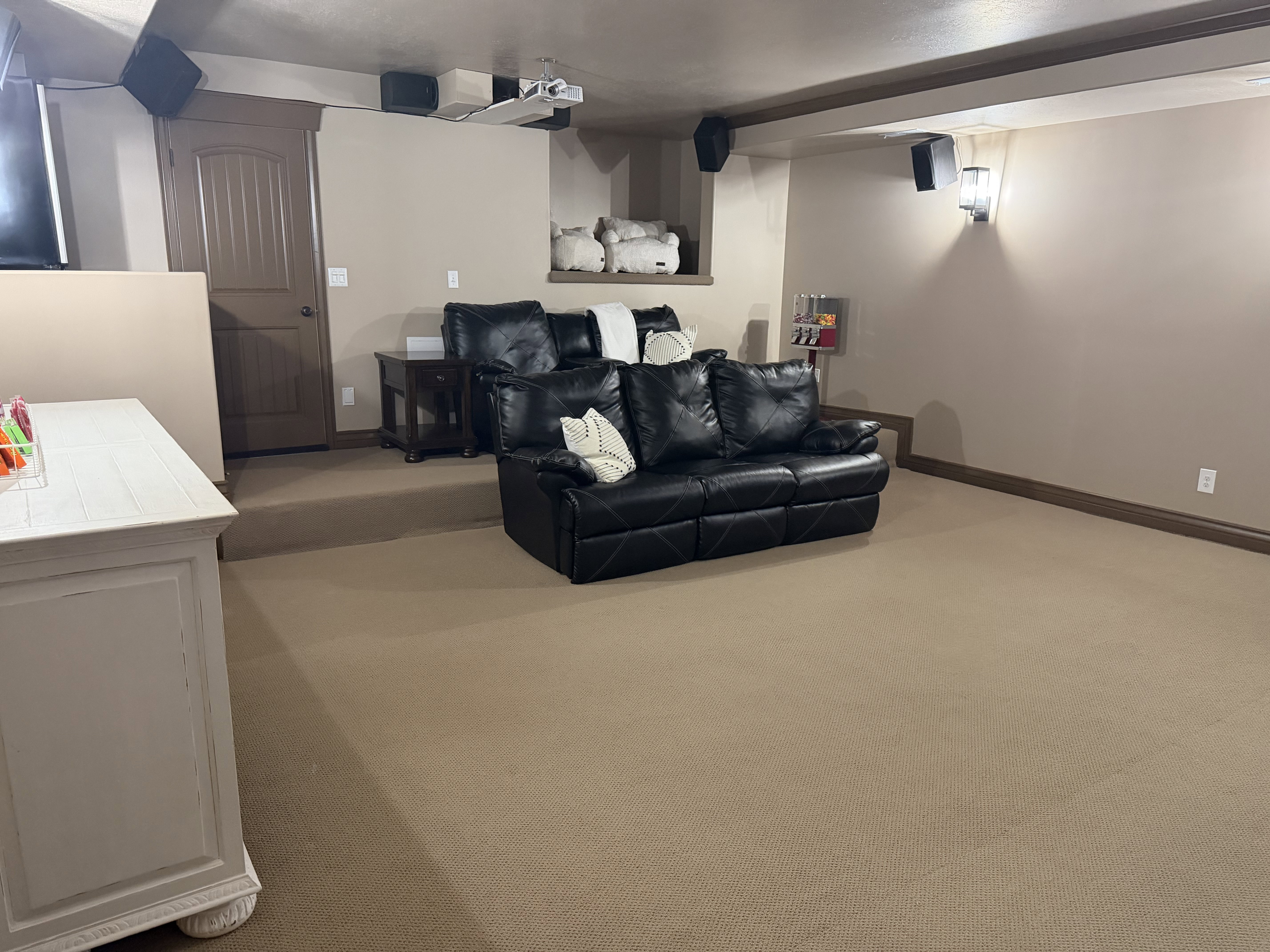 Cinema room featuring light colored carpet and baseboards