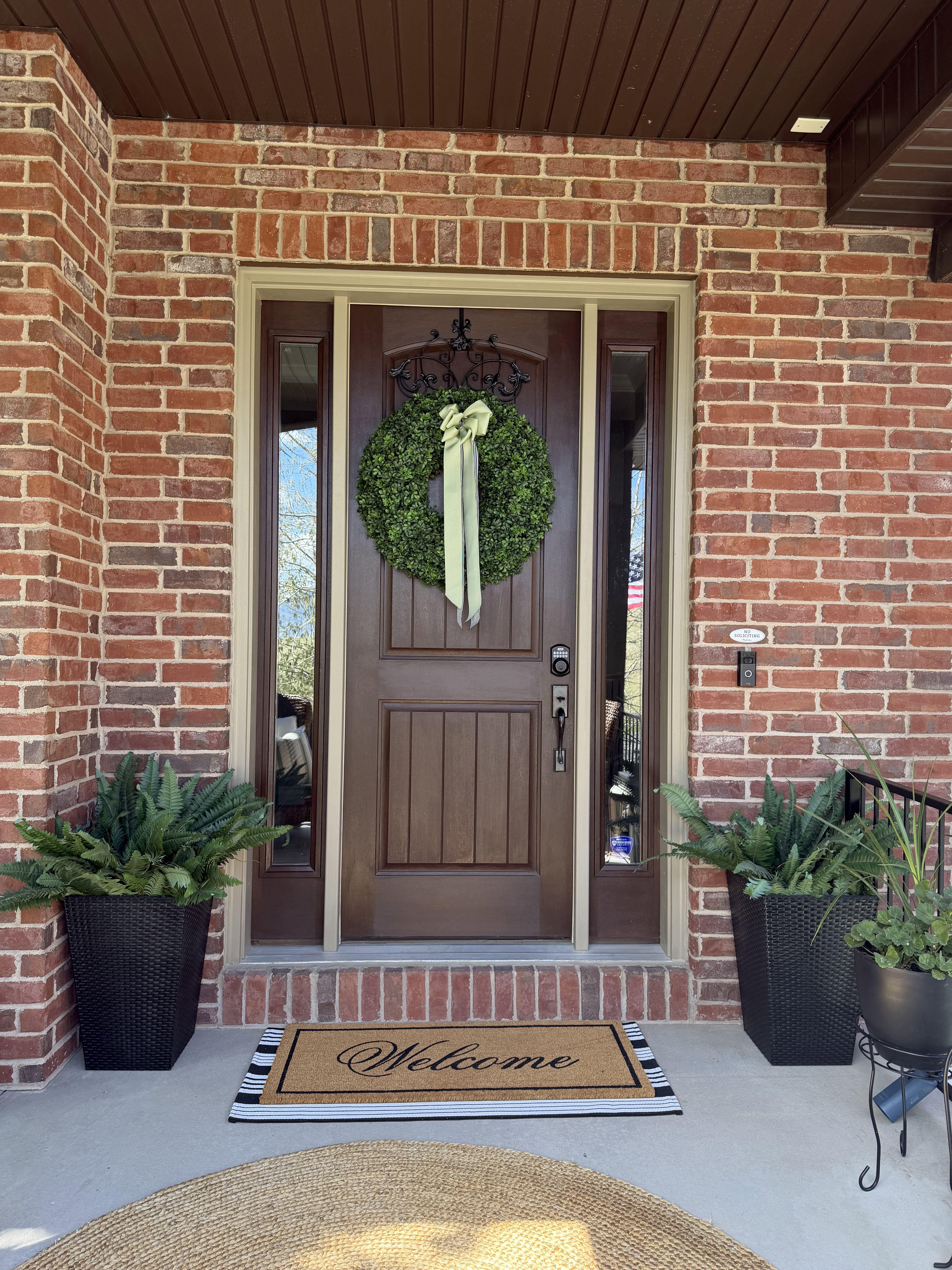 View of exterior entry featuring brick siding and covered porch
