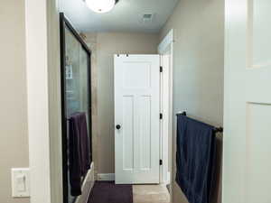 Bathroom with a textured ceiling and a shower