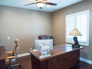 Office space featuring dark wood-style flooring and ceiling fan