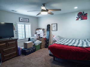 Carpeted bedroom featuring a ceiling fan