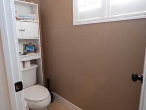 Bathroom with toilet and light tile patterned flooring