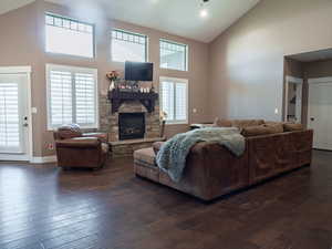 Living room featuring vaulted ceiling, dark wood finished floors, and a fireplace