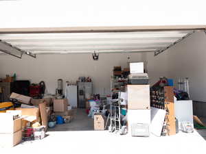 Garage featuring stainless steel refrigerator with ice dispenser and freestanding refrigerator