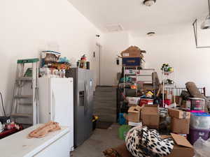 Garage featuring freestanding refrigerator, stainless steel fridge with ice dispenser, and a garage door opener