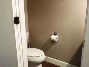 Bathroom with a textured wall and dark wood finished floors