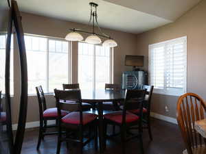 Dining area with baseboards and dark wood-style floors