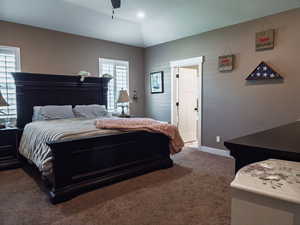 Bedroom with carpet floors, ceiling fan, and lofted ceiling