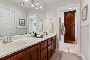 Full bath featuring double vanity, light tile patterned flooring, and light colored carpet