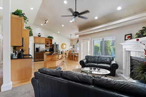Living area featuring ceiling fan, recessed lighting, a fireplace, and vaulted ceiling