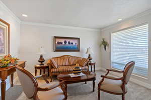 Living area featuring light carpet, crown molding, and recessed lighting