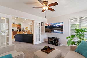 Living area with carpet, a ceiling fan, lofted ceiling, and french doors