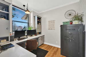 Office with large window and crown moulding, and custom built in cabinets