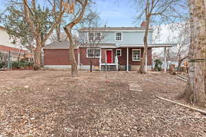Traditional-style house featuring brick siding, a chimney, and entry steps