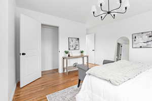 Bedroom with light wood finished floors, and a chandelier