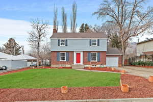 Colonial-style house with a grassy front yard with rv parking