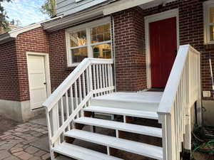 Entrance to property featuring brick siding and covered porch