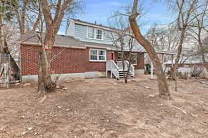 View of front of house featuring brick siding and roof with shingles