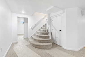 Stairway with baseboards and carpet floors