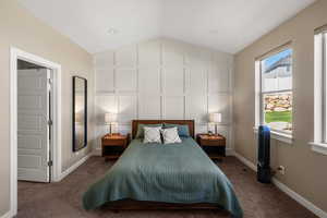 Bedroom with baseboards and dark carpet