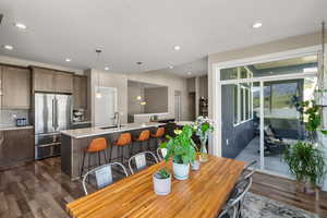 Dining space with dark wood-type flooring and recessed lighting