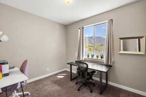 Home office with dark carpet and a mountain view
