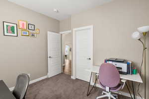 Carpeted office space featuring baseboards