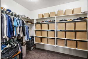 Walk in closet featuring dark carpet
