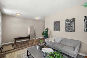 Living area with baseboards and wood finished floors