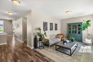 Living area with baseboards and dark wood finished floors