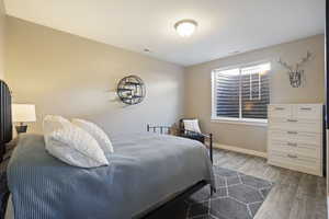 Bedroom featuring wood finished floors and baseboards
