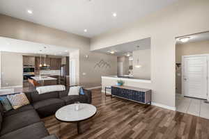 Living room with dark wood-style floors and recessed lighting