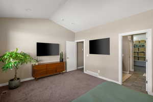 Carpeted bedroom with vaulted ceiling and baseboards