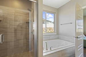 Bathroom featuring a shower stall, a garden tub, and ensuite bathroom