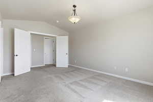 Unfurnished bedroom with light carpet and baseboards