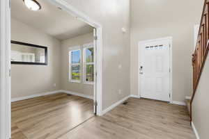 Entrance foyer featuring light wood-style floors and lofted ceiling